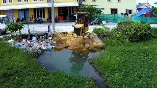 Bulldozer push soil into the water for fill up the small land