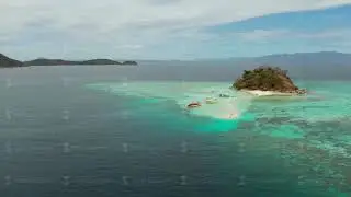 Small torpic island with a white sandy beach, top view.