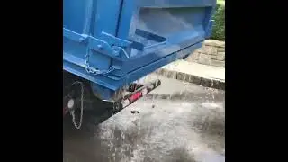 Isuzuz NRR 36 inch Stellar hook lift draining water out of dumpster during pick up in New Canaan CT