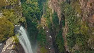 A Waterfalls From High Atop A Mountain To A River