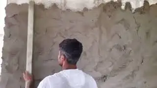 Applying wall plaster on concrete brick wall.