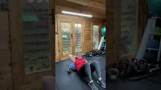 Back exercise - pullover on the wobble board in the hamstring bridge position with kettle bells.  