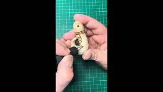 Carving a fish hook pendant from driftwood.