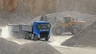 Volvo L180F in quarry with trucks