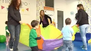 Juego de estimulación psicomotriz para los niños con un paracaídas