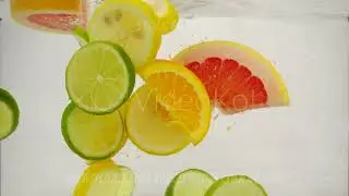 Pieces of citrus fruits lime, lemon, orange, grapefruit fall into the water with splashes and