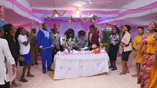Bishop Rahab cutting a cake at 100k subscribers celebration.