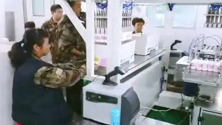 round bottles labels applicator barcode printer inline with robot pickup feeding carton packaging
