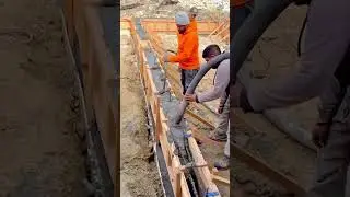 Pouring Concrete Mix into Wooden Formwork for a Trench Foundation