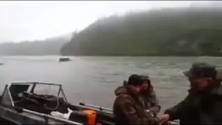 Toyota Landcruiser drives down the middle of a running river past a fishing boat!
