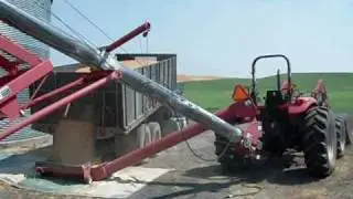 Unloading wheat into auger in small storage bin