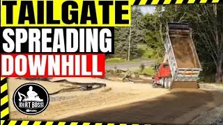 Dump truck tailgate spreading stone down steep grade Tri-County  Excavating