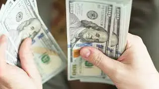 Caucasian hands counting a stack of hundred us dollar banknotes