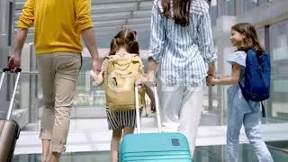 STOCK VIDEO | Rear View Of Family With Two Children Going On Holiday, Walking At The Airport
