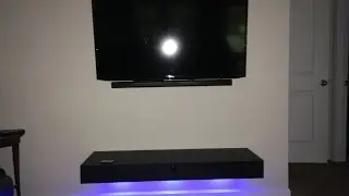 Floating shelf with lights and a door.