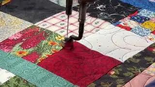 Swirls and paisleys on a scrappy nine patch quilt.  