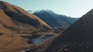 Drone reveal of Moke Lake surrounded by Mountains - Couple dancing by lakeside - Moke Lake Timelapse