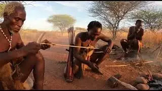Hadzabe bushmen sharpening wooden arrows before a small hunt