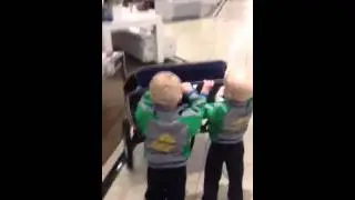 Twins boys pushing shopping cart