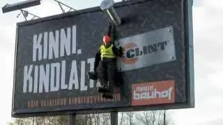 Construction worker hanging on billboard
