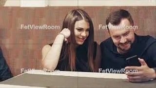 Young couple sitting in cafe and using mobile phone.