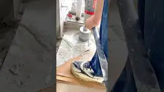 Worker drilling into concrete floor using a core drill machine
