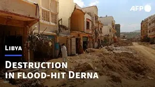 People walk amid rubble in Libya's flood-hit Derna | AFP