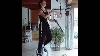 Girl perfect knife juggling while riding unicycle - 1314317