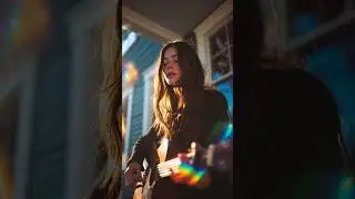 Close up on the guitar as she fingerpicks the strings