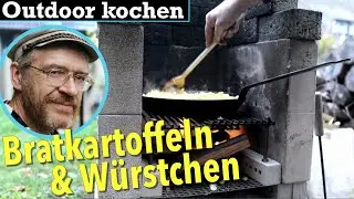 Outdoor kochen Bratkartoffeln aus rohen Kartoffeln Würstchen über Feuer