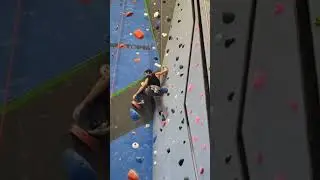 Jon climbing Trinity's orange shelf.
