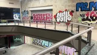 Walking through a abandoned mall covered in graffiti 