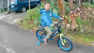 A little boy learning to ride a small bike - he seems very happy.