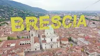 Inscription on video. Brescia, Italy. Cathedral of Santa Maria Assunta. Flight over the city in clou
