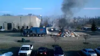Garbage truck trash on fire.