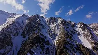 Majestic snow-covered mountains in clear blue sky, drone view