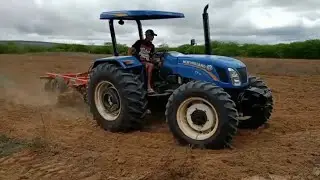 Trator New Holland TT75 preparando a terra para o plantio e grandeado com a grade  de 14 dicos
