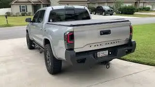 Тонированные задние фонари на Tacoma 2018 года выпуска. &laquo;Светодиодные задние фонари со светодиодной полосой; черный корпус; тонированные линзы&raquo;.