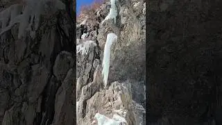 Massive ice formation falls to the ground with one swing of the ice tool.