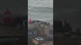 Biggest waves of the world go almost above a lighthouse