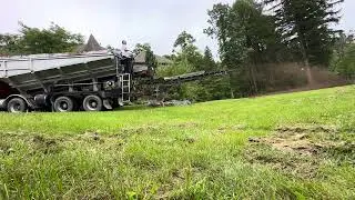 Spreading topsoil with stone slinger truck