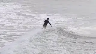 Surfers enjoy cold waves at the M.B. Miller County Pier in Panama City Beach.
