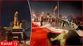Angry protesters lower Iranian flag, burn regime statues and portraits