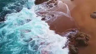 Aerial top shot of a coastline where the ocean meets the shore FREE STOCK VIDEO