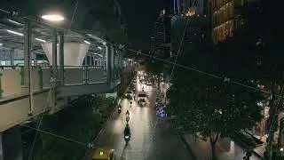 High angle view of bustling street in Bangkok, Thailand, at night. Cars, taxis, and motorcycles flow