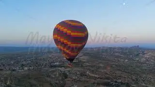 Goreme, Nevsehir, Turkey. Large colorful checkered hot air balloon with big basket and fire burst...