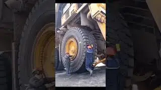 Mechanic fixing wheel of a huge dump truck