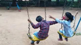 kids have fun on swing in empty park during pandemic