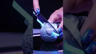 Ultra-realistic cinematic close-up of a woman&rsquo;s hand cutting Pluto using a glowing luxury knife.