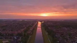 Flying Over A City Canal At Sunset